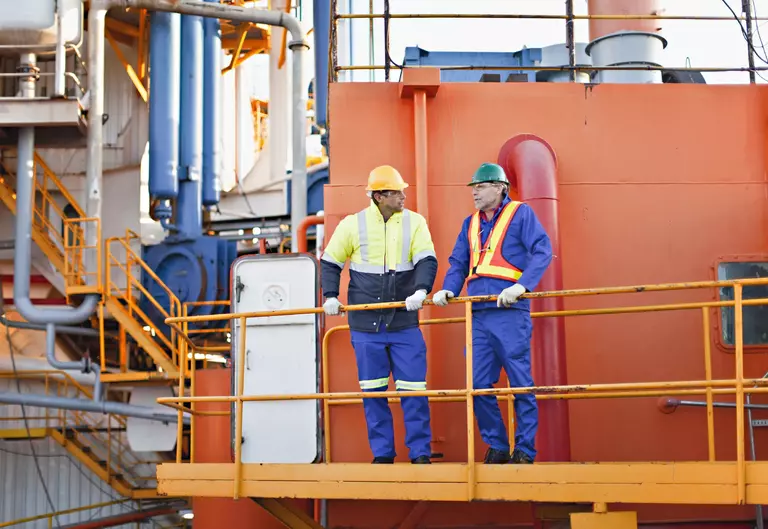 Workers talking on oil rig Workers talking on oil rig