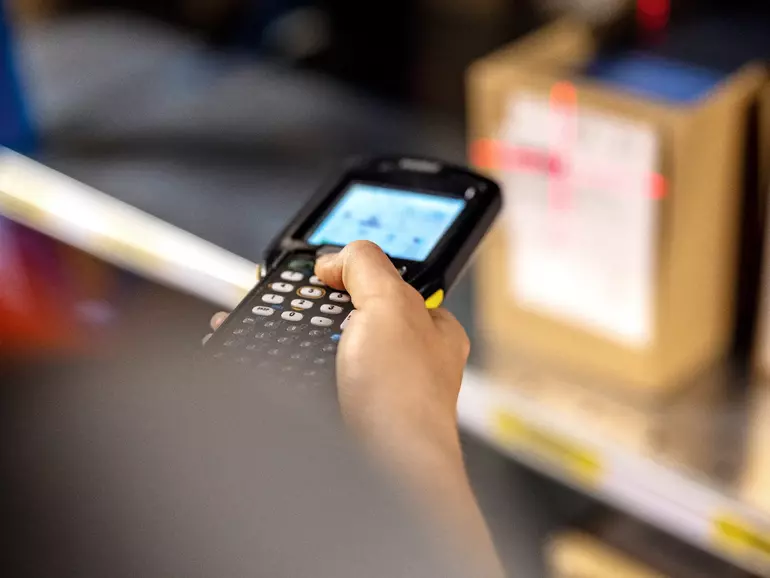 Close up of a warehouse worker scanning boxes in rack