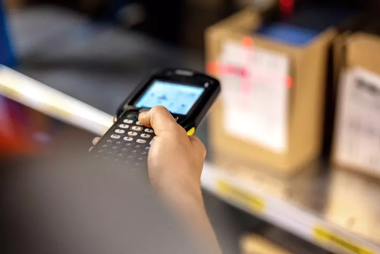 Close up of a warehouse worker scanning boxes in rack