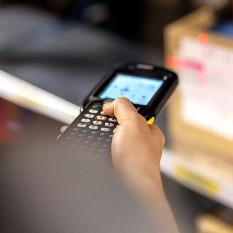 Close up of a warehouse worker scanning boxes in rack