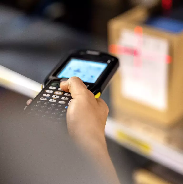Close up of a warehouse worker scanning boxes in rack