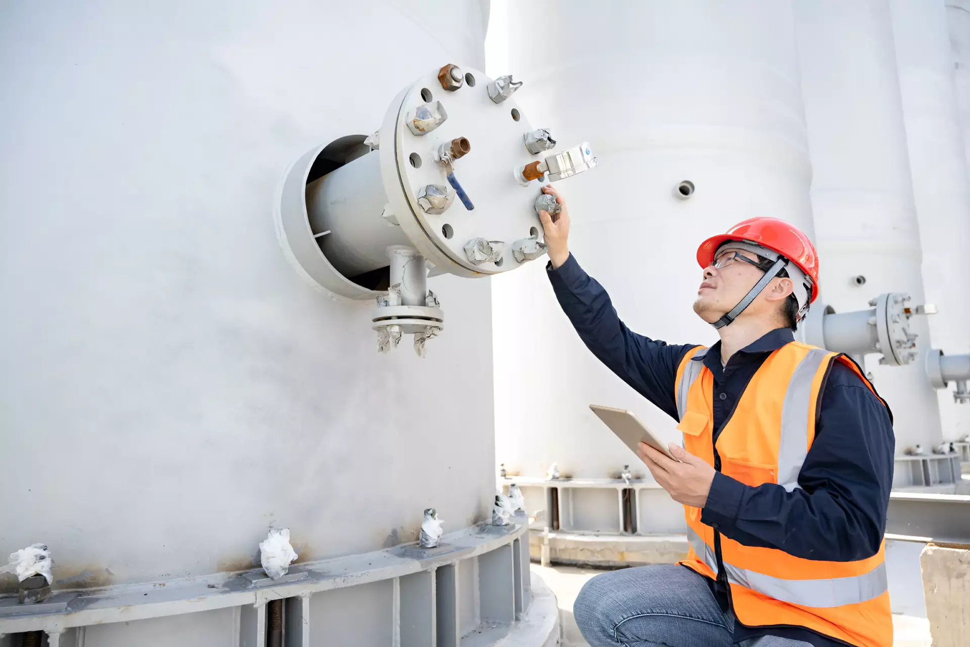 Engineer using tablet to check pressure of tank