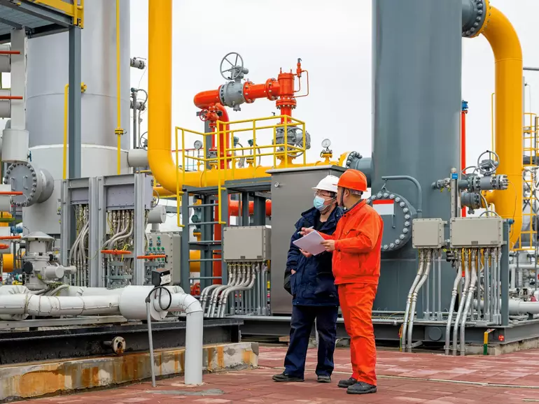 Engineers and staff communicate on site in chemical plant
