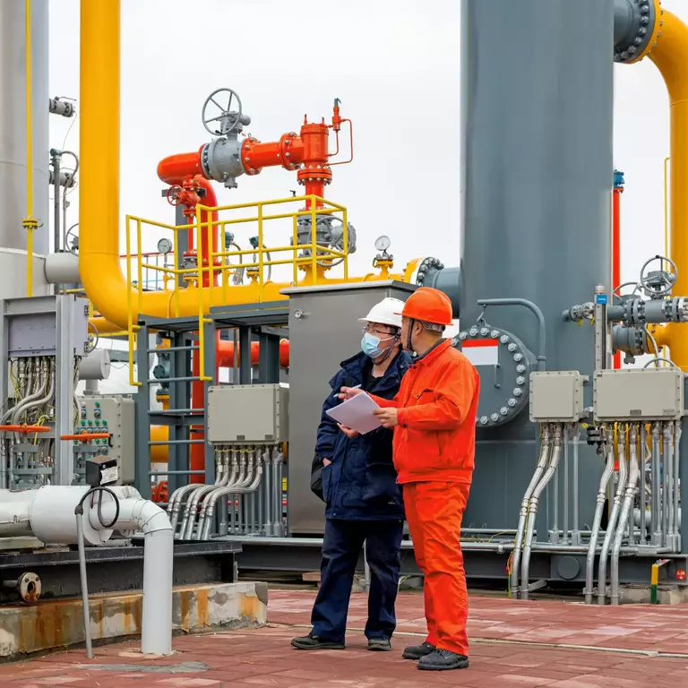 Ingenieure und Mitarbeiter kommunizieren vor Ort in der Chemiefabrik