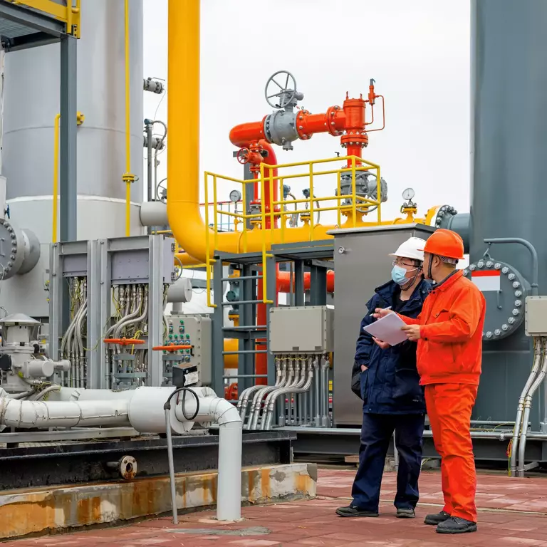 Engineers and staff communicate on site in chemical plant