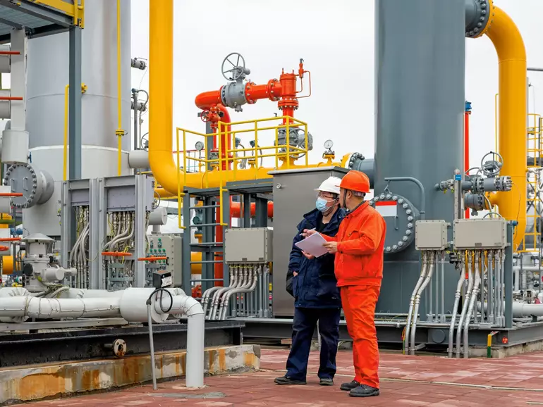 Ingenieure und Mitarbeiter kommunizieren vor Ort in der Chemiefabrik