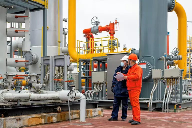 Engineers and staff communicate on site in chemical plant