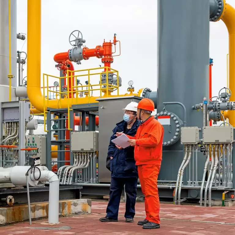 Engineers and staff communicate on site in chemical plant