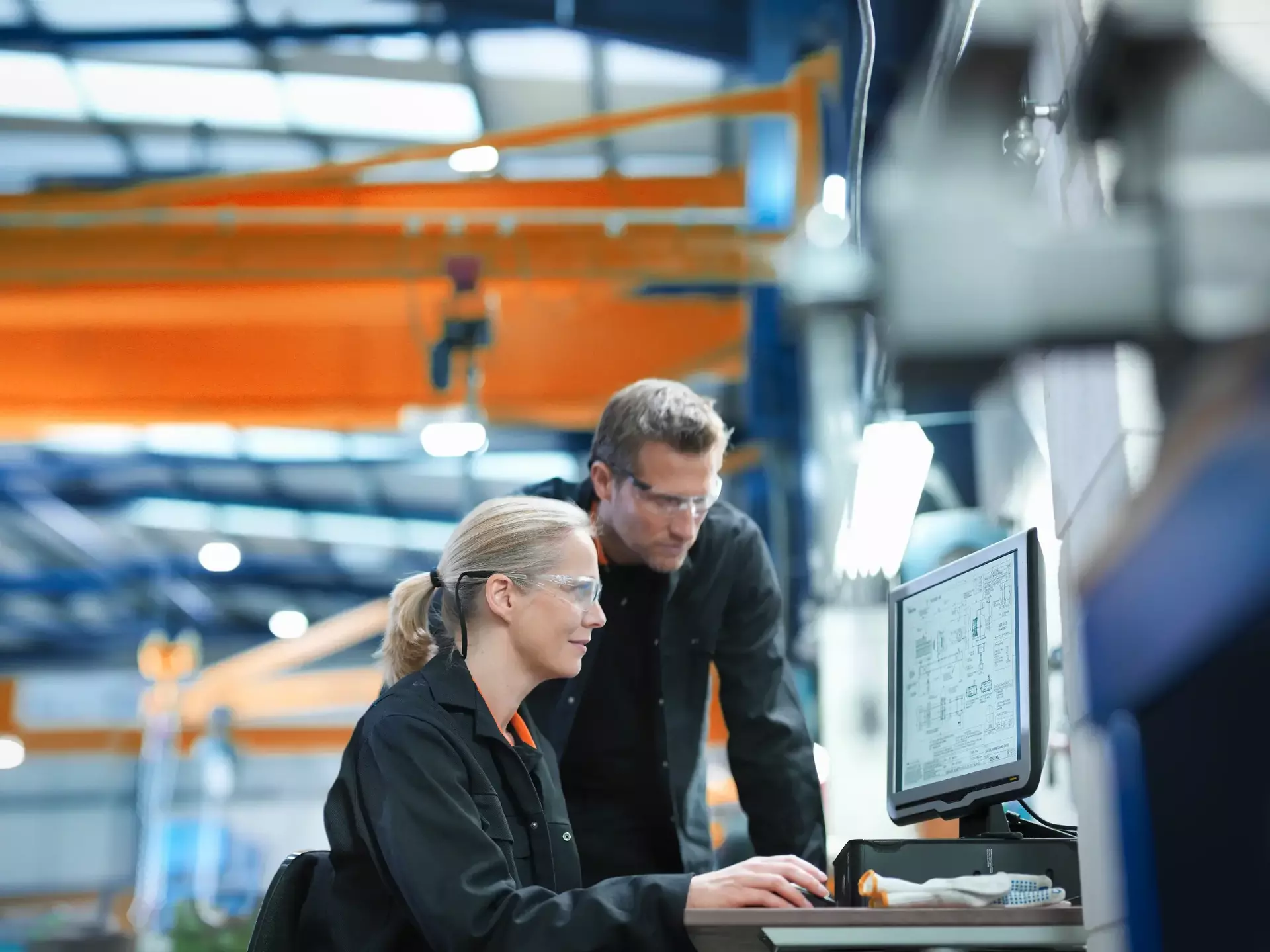 Ingenieure arbeiten am Computer an Plänen in einer Maschinenfabrik