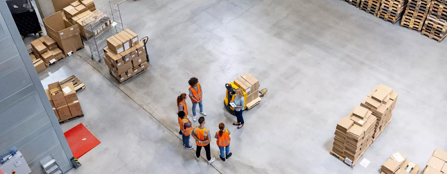 Besprechung des Versandteams im Lager aus einem hohen Winkel