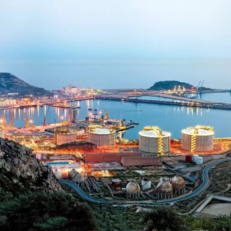 Petrochemical plant and oil refinery industry by the sea at sunset