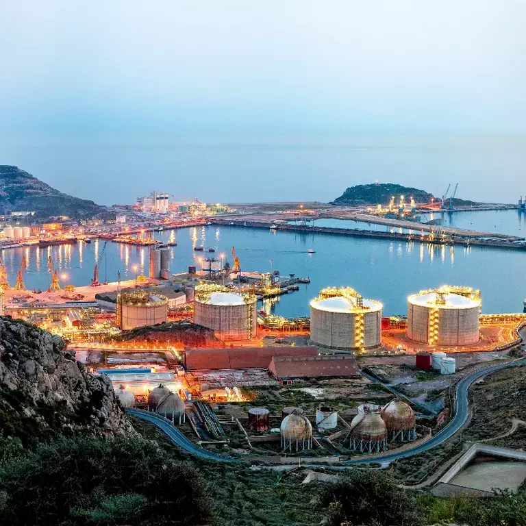 Petrochemical plant and oil refinery industry by the sea at sunset